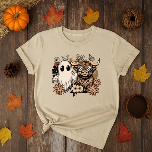 Beige Halloween t-shirt with ghost and highland cow graphic surrounded by flowers.